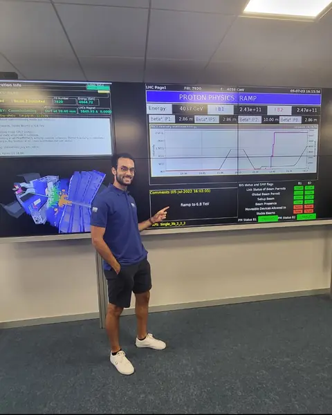 Ahmed in the LHCb control room, pointing at a screen that reads 'Ramp to 6.8 TeV'