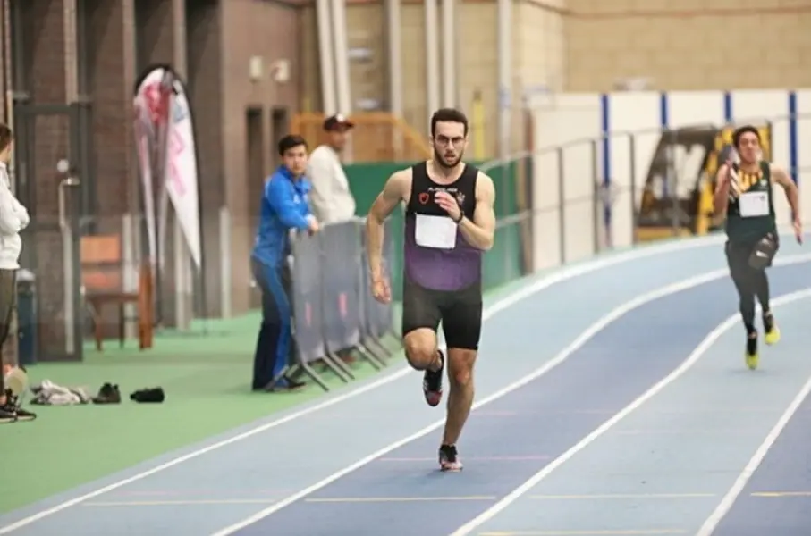 Ahmed sprinting on an indoor athletics track